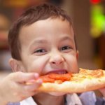 Ребенок, поедающий пиццу