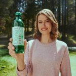 A woman holds a Donat Mg bottle in her hands.